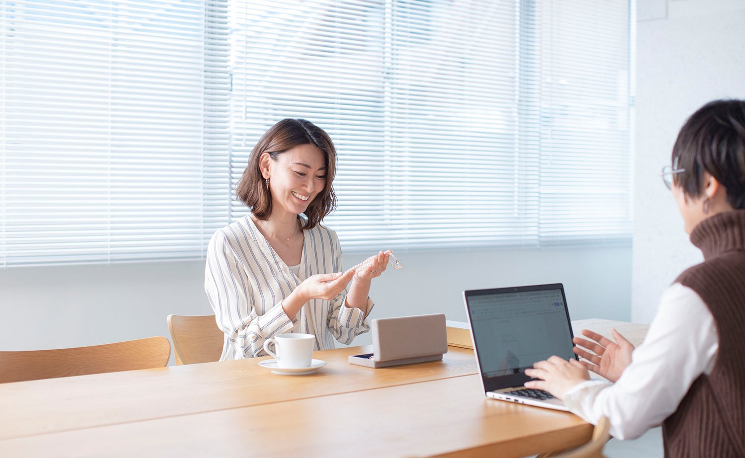 パールネックレスを手に取るブリリアンスプラス スタッフ