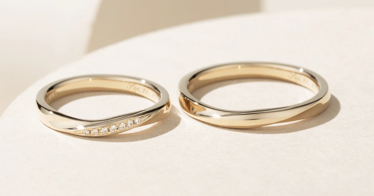 細めのウェーブのフォルムがお気に入り。お揃いで選んだシャンパンゴールドの結婚指輪