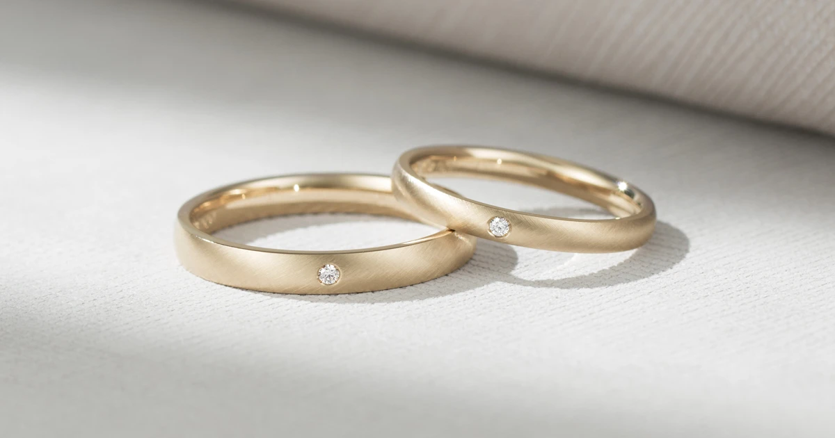 お互いの好みを少しずつ重ねてお揃いに。マットな質感とシャンパンゴールドが美しい結婚指輪