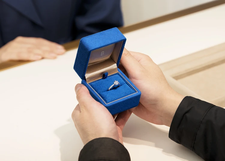 リングケースを渡すカスタマーサポートの手